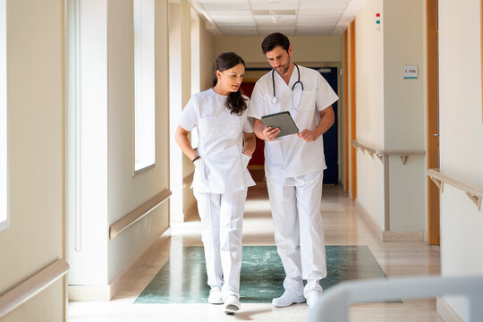 Healthcare professionals discussing patient care in hospital corridor