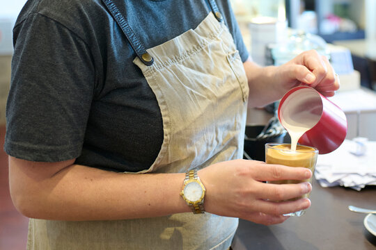 Barista Pouring Coffee in a Cozy Caf&eacute; Setting