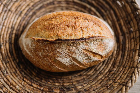 Golden crusted artisanal bread in a woven wicker basket.