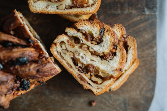 Close-up of sliced nut-filled bread on wooden board.