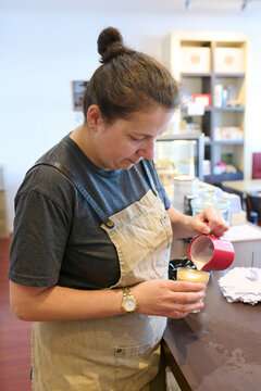 Barista Pouring Coffee in a Cozy Caf&eacute; Setting