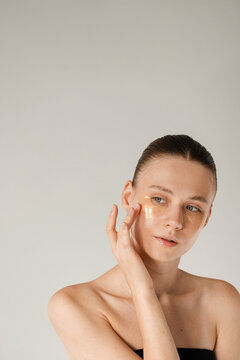 Young model posing with her hand near the face on white background 