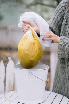 Natural dye filtration process over bucket outdoors