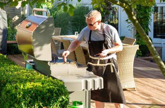 Man cooking burgers on a gas bbq