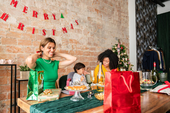 Gift exchange moment at Christmas dinner indoors - Powered by Adobe
