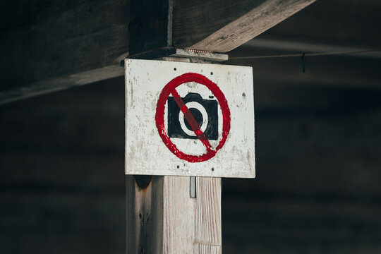 No Photography Allowed Sign on Wooden Post with Red Circle and Slash