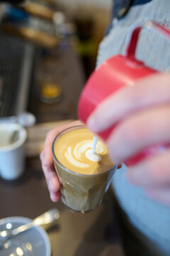 Artisan Barista Pouring Decorative Foam Into Latte at Caf&eacute;