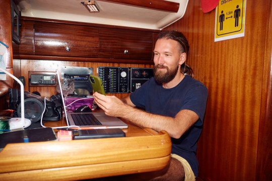 Smiling man works from below deck of a ship