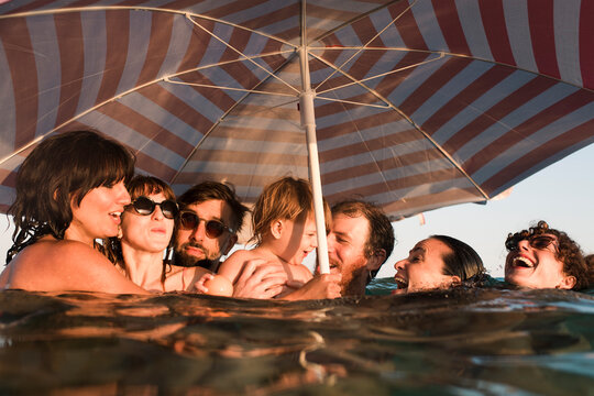 Cheerful group of friends with cute baby in the sea