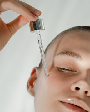Applying serum to the skin of the face close-up