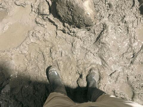walking with rubber boots on muddy ground