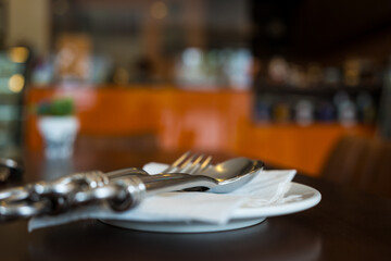 Selective focus  fork and spoon lies on a paper napkin at cafe