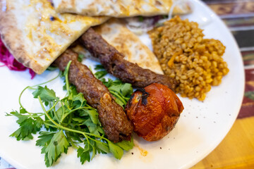 Urfa Kebab, traditional Turkish cuisine with kebab meat, vegetables on the plate in Sanliurfa, Turkey