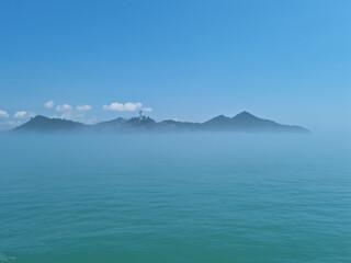 It is a foggy sea and island.