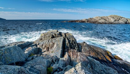 Norwegian sea waves crashing on a rocky shore, sunny day on Sotra Island in Norway.
