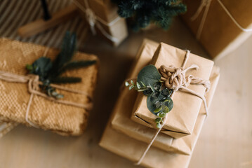 Sophisticated gift wrapping in kraft paper using natural elements such as pine twigs and eucalyptus.