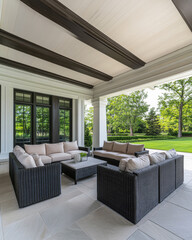 Fototapeta premium Cozy outdoor seating arrangement on a spacious patio surrounded by lush greenery at midday