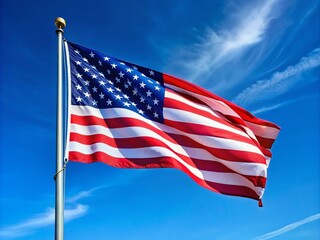 Obraz premium Waving American Flag on a Tall Pole Against a Clear Blue Sky Symbolizing Freedom and Patriotism