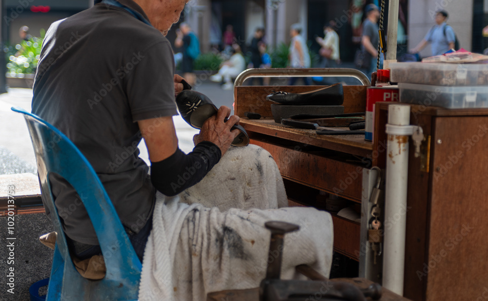 Wall mural shoemaker repairing shoes in the street in singapore