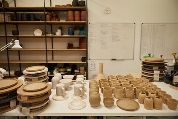 Variety of earthenware sitting on a tables in a ceramics workshop