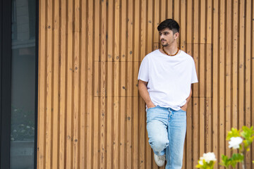 young man in the street leaning on the wall