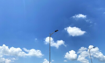 Street Lamp Post on a Bright Sunny Day, A single street lamp post stands tall on a blue sky day,...