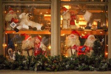 Close-up of a decorated window during Christmas, showcasing miniature festive figurines. The scene captures the spirit of the holiday season with detailed ornaments and cheerful decorations