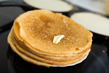 Cooking traditional pancakes from wheat flour in the kitchen