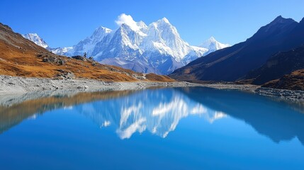 A tranquil blue lake reflecting the surrounding snow-capped mountains under a clear sky.