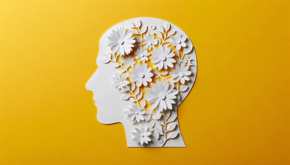 Paper cut-out head silhouette with blooming flowers, symbolizing growth and mental well-being on a bright yellow background