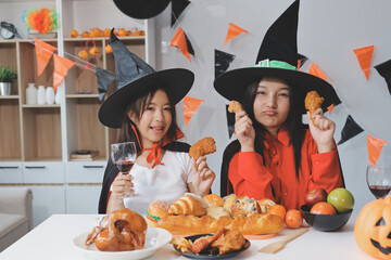 friendship, holiday and people concept - group of happy smiling friends in halloween costumes of vampire, devil, witch and cheetah at home party