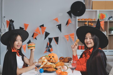 friendship, holiday and people concept - group of happy smiling friends in halloween costumes of vampire, devil, witch and cheetah at home party