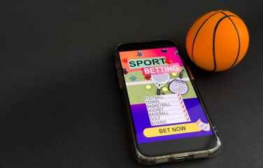 smartphone with application for sport bets and a basketball ball, concept of online bets 