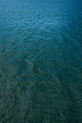 Glare and reflective surface water on the lake. Water surface abstract background of a lake or sea water pattern with small waves. Water texture