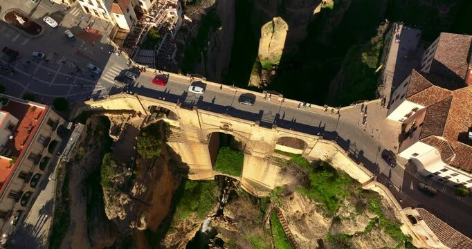 Ascending aerial shot of Ronda City in Spain, Europe. Arch bridge, homes, streets are located on the cliff. Mountains are visible in the background. High quality 4k prores footage.