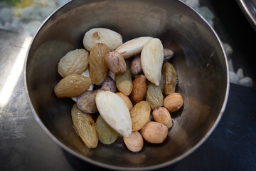 Peanuts, almonds, raisins etc. in steel bowl.