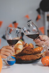 friendship, holiday and people concept - group of happy smiling friends in halloween costumes of vampire, devil, witch and cheetah at home party