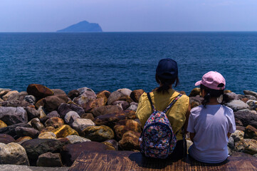 Peaceful Moment on Taiwan's East Coast &ndash; Mother and Daughter Gaze at Guishan Island
