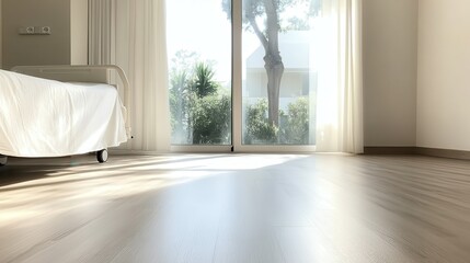 Fototapeta premium A minimalist hospital room is beautifully lit by natural sunlight streaming through a large window, offering a calming view of trees and greenery outside.