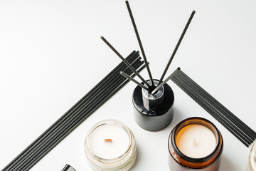 Aromatic essentials including scented candles, incense sticks, and diffusers arranged on a light background