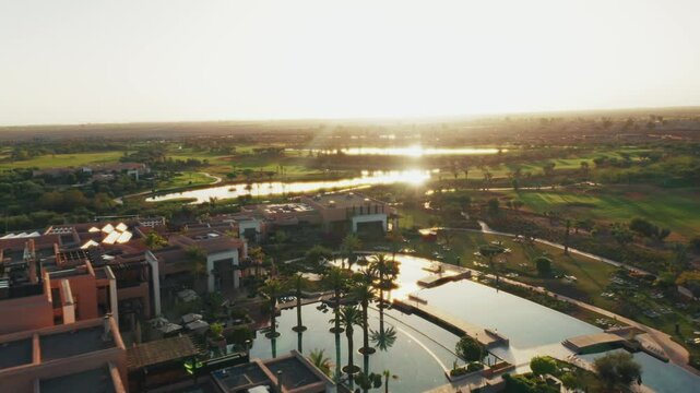 Aerial drone shot over the Fairmont luxury resort in Marrakesh. High view of the palm trees and the outdoor pools. High-end luxury hotel for relaxing vacations and leisure.