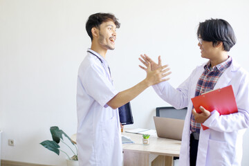 Fototapeta premium Two Asian Medical Students Shaking Hands At Hospital 
