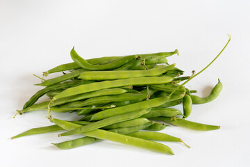 Freshly harvested organic pile of climbing French bean, Blue Lake variety, on white background. Juicy and round pods.