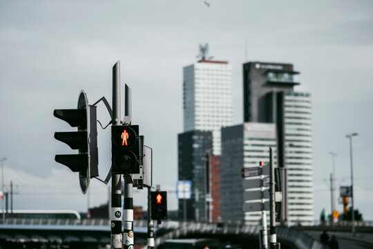 This image features a cityscape with prominent skyscrapers in the background and a close-up view of traffic lights, highlighting urban architecture and infrastructure in Rotterdam