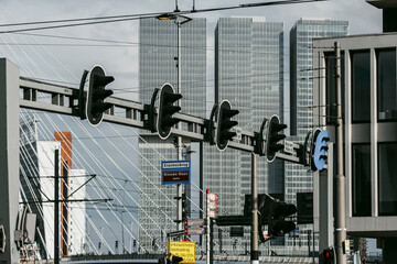Tall skyscrapers dominate the background while an arrangement of traffic lights captures movement and directionality, illustrating urban flow and modernity in Rotterdam