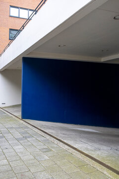 A minimalist architectural scene features clean lines and a striking blue accent wall, showcasing simplicity, modernism, and the interplay of color and form.