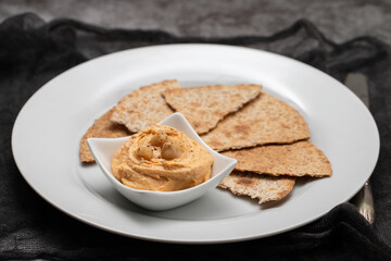 Classic chickpea hummus with, olive oil and toasts on plate