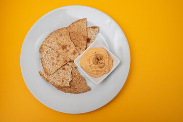 Classic chickpea hummus with, olive oil and toasts on plate