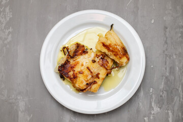 fried spicy fish with olive oil on white plate