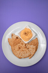 Classic chickpea hummus with, olive oil and toasts on plate
